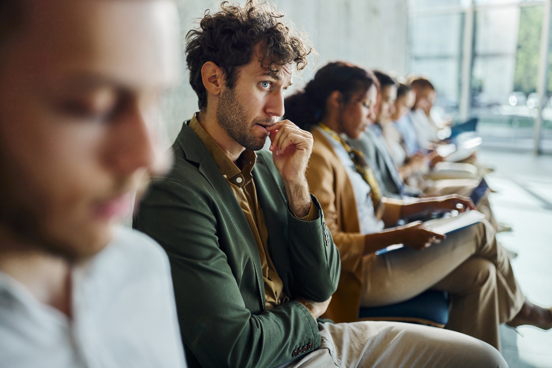 Man sitting among row of people looking worried