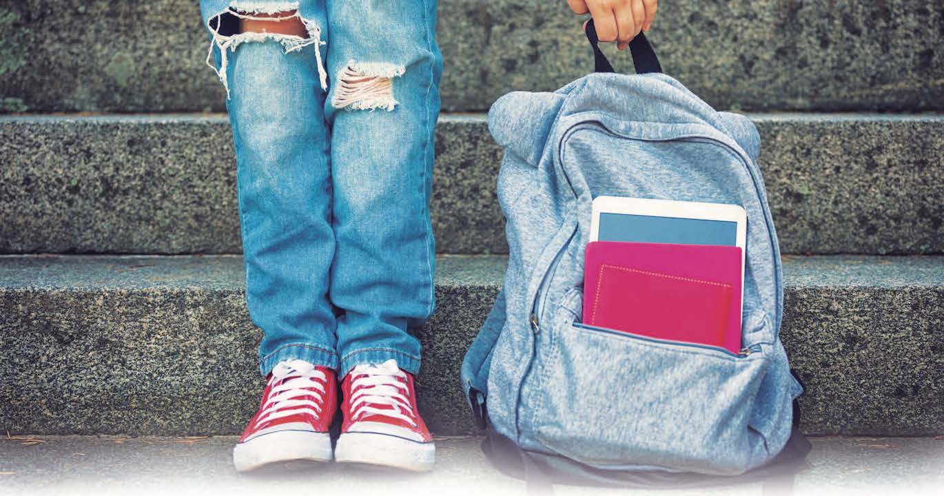 child holding backpack