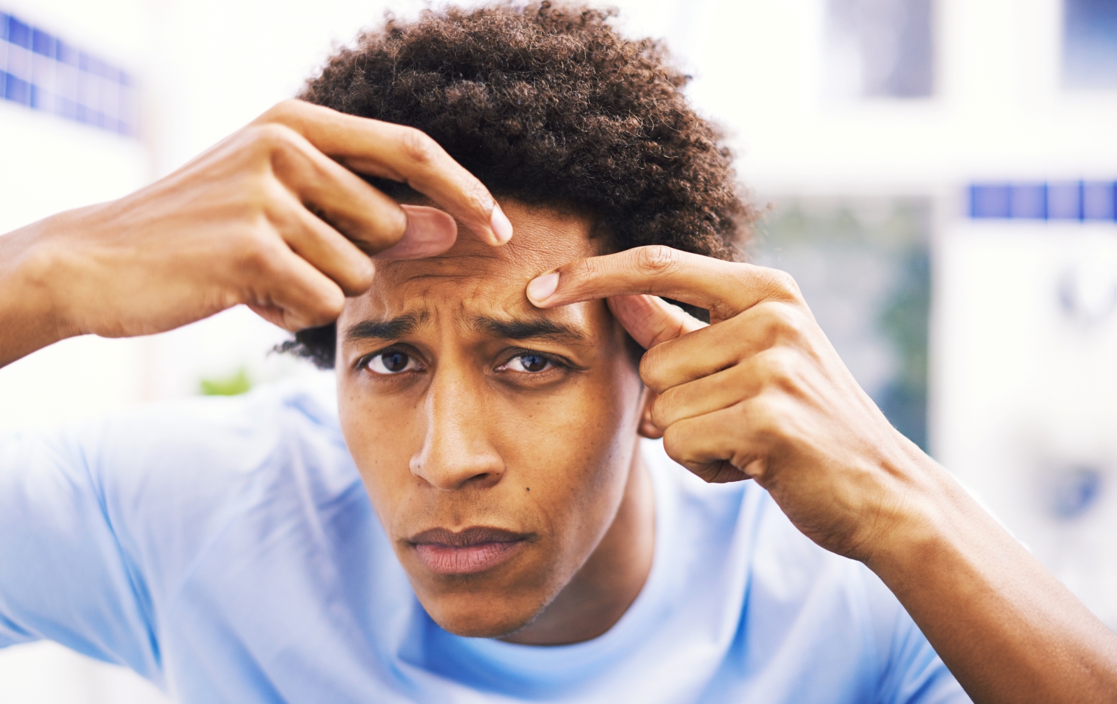 Man pointing at spot on forehead with both hands