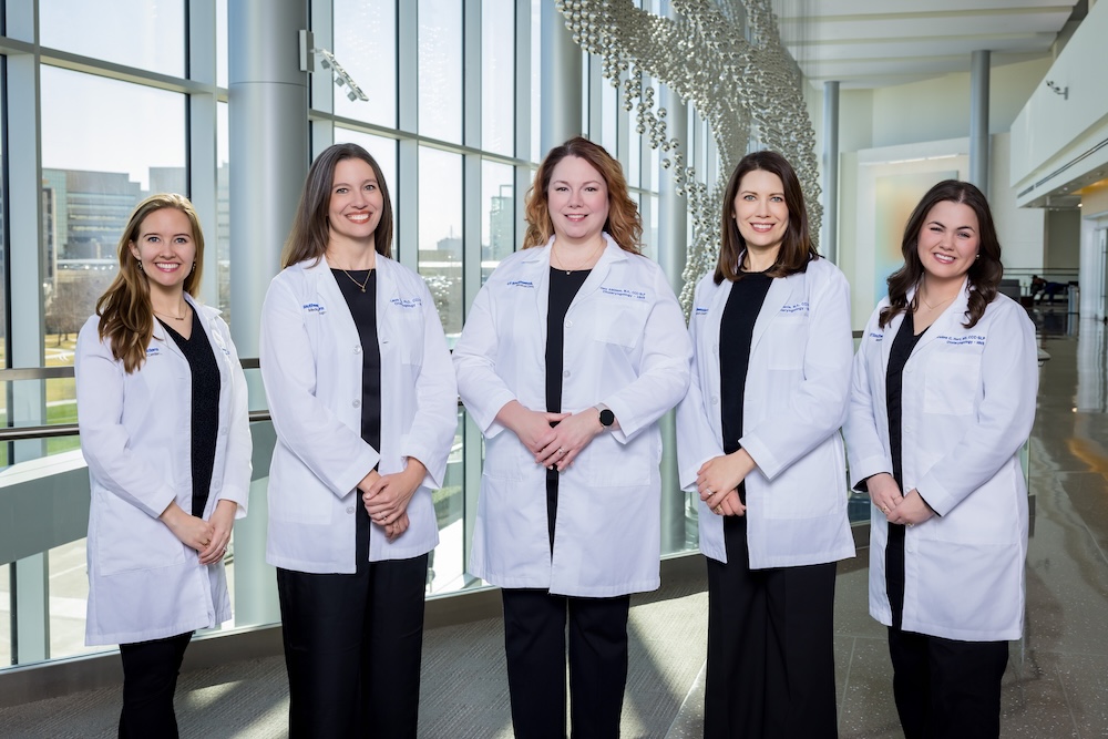 Speech-language pathologists standing together in a hospital corridor