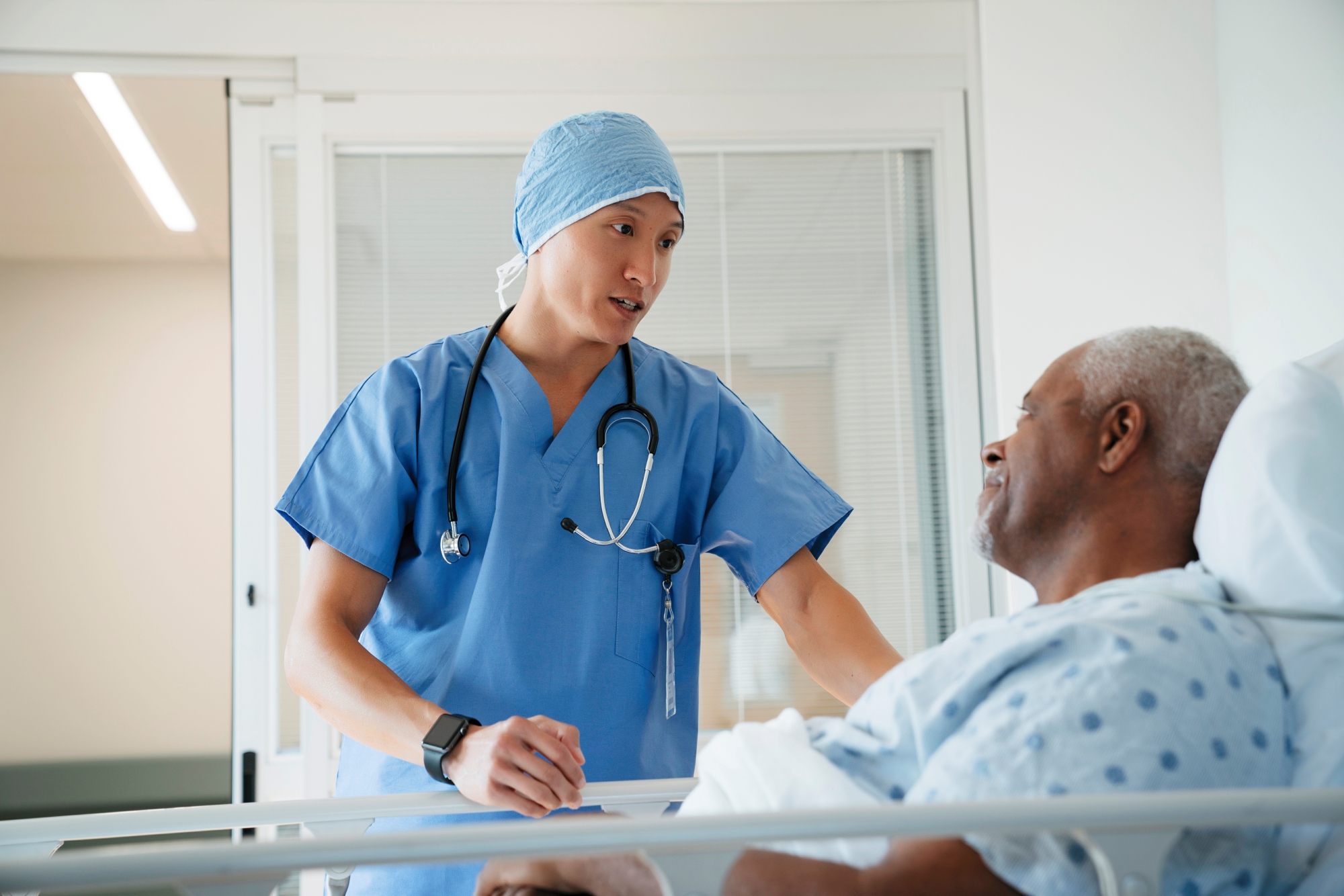 Surgeon talking with patient in hospital bed