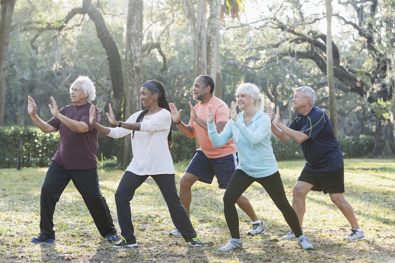 Seniors doing tai chi outside.