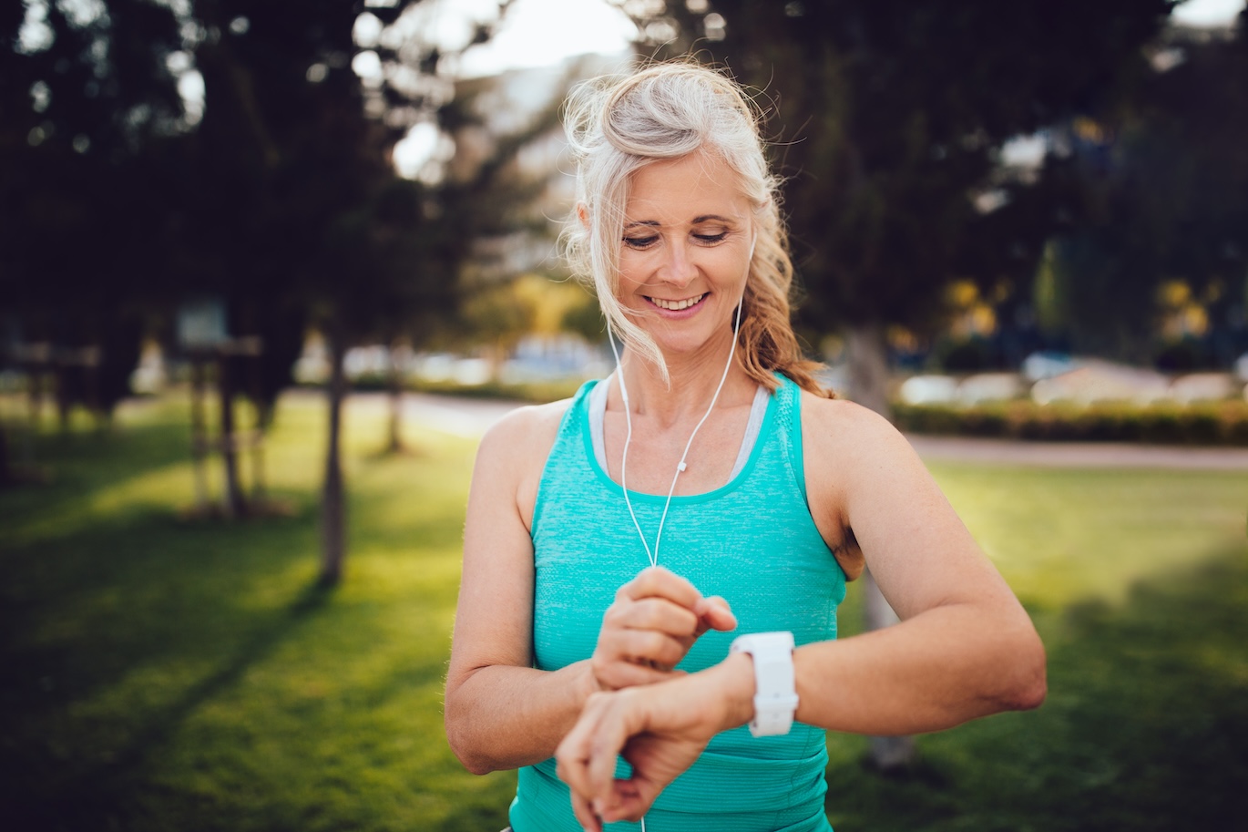 Athletic mature woman monitoring her running performance on smartwatch