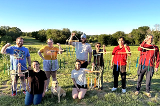 young adults outdoors holding up windchimes