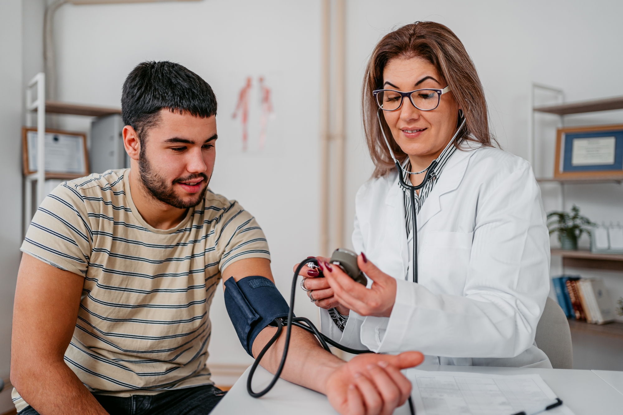Young man getting blood pressure checked by physician